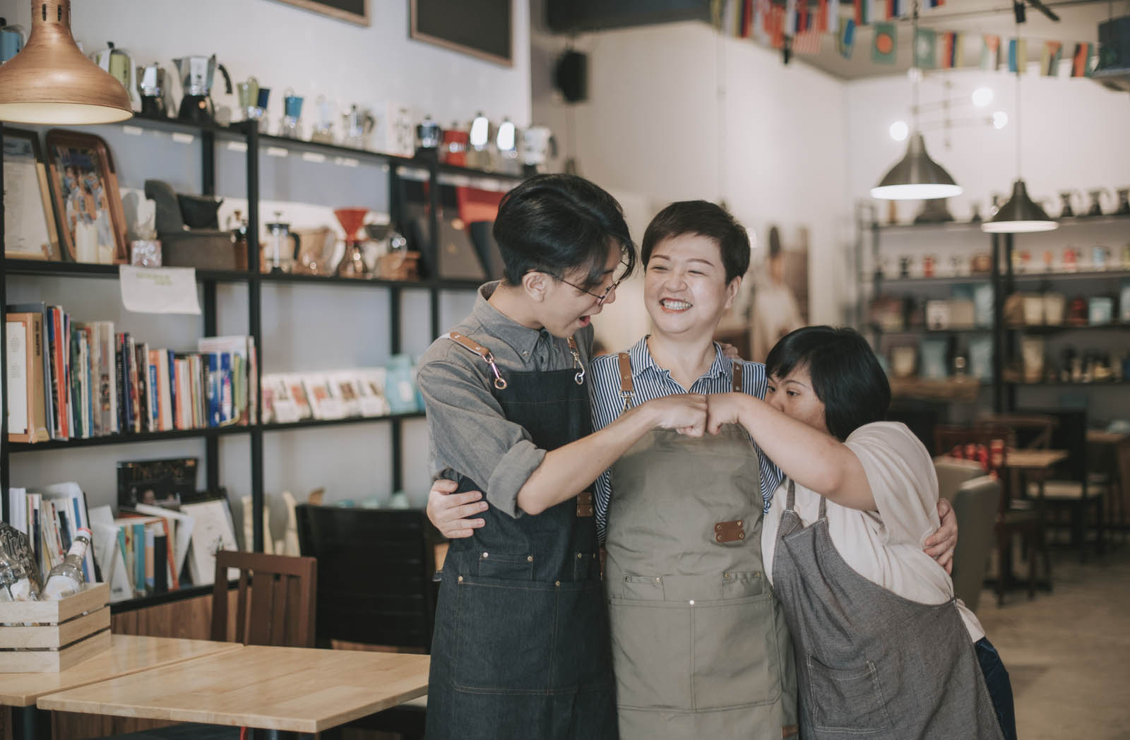 asian cafe down syndrome disability employee and owner fist bump bonding time in cafe happily